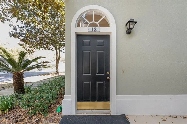 a view of staircase with white walls and white door
