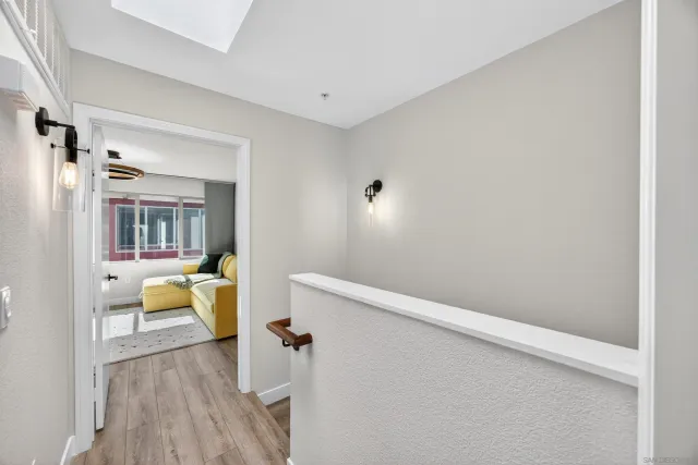 a view of a hallway with wooden floor and staircase