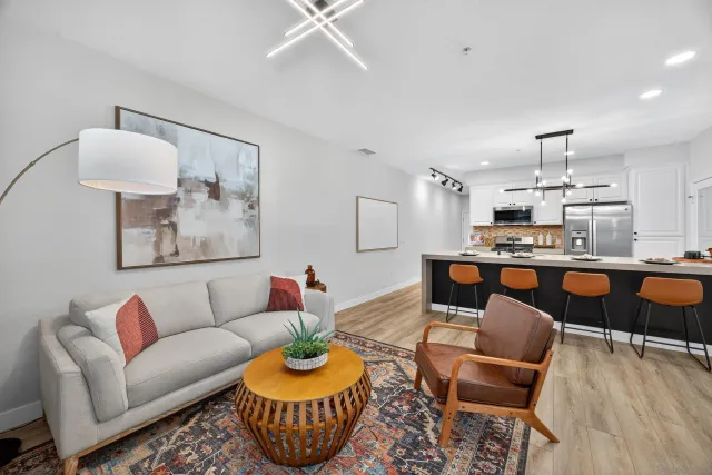 a living room with furniture and a dining table with wooden floor
