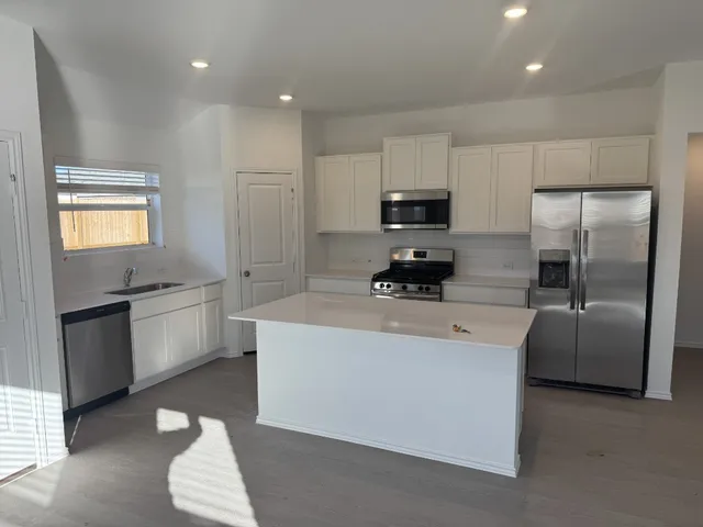 a kitchen with stainless steel appliances a refrigerator sink and microwave
