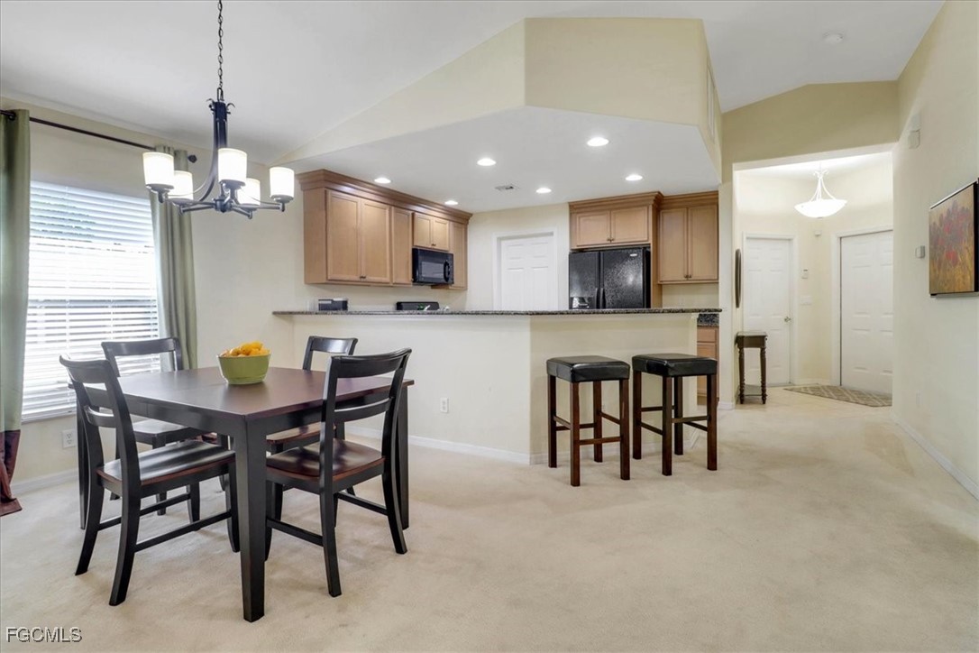 19674 Villa Rosa Loop Estero, FL 33967 - Photo 6 of 33 a kitchen with stainless steel appliances granite countertop a table chairs and a refrigerator
