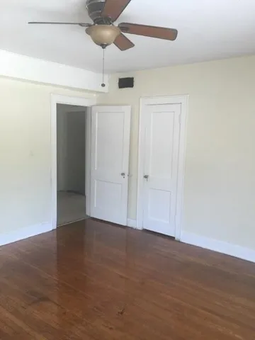 an empty room with wooden floor chandelier fan and closet in wooden floor