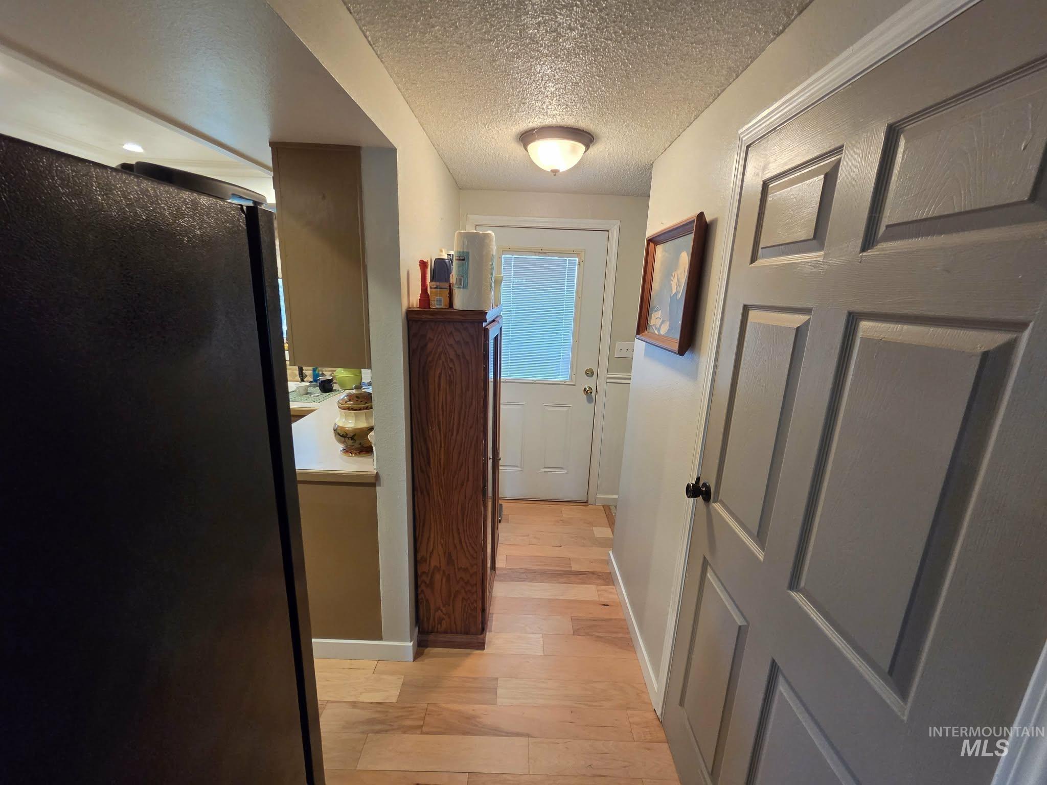 1535 Sunnyside Road Weiser, ID 83672 - Photo 9 of 26 Wood-finish flooring extending through the hallway, interior paneled doors, and a ceiling-mounted light fixture