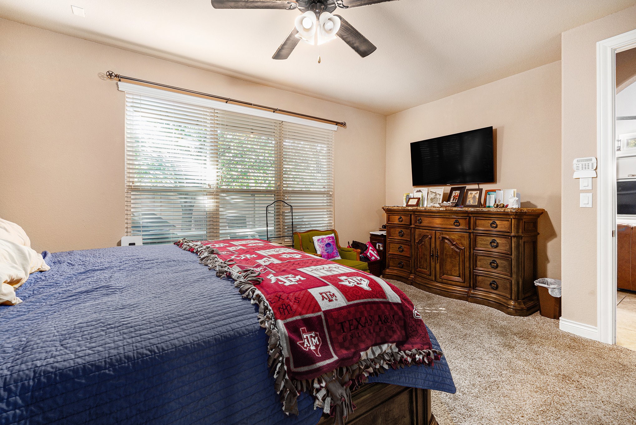 9039 Centennial Drive Conroe, TX 77384 - Photo 7 of 16 a bedroom with a bed and a flat tv screen on wall