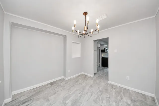 a view of an empty room with a chandelier