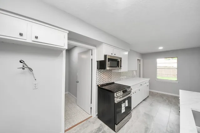 a kitchen with stainless steel appliances granite countertop a sink and a stove top oven