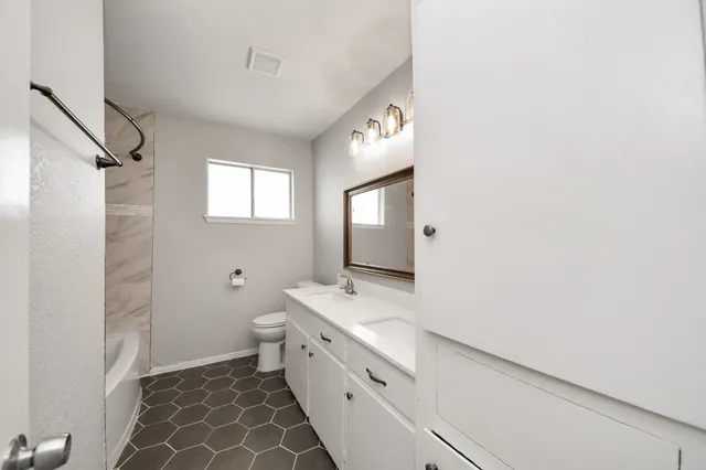 a bathroom with a double vanity sink mirror and toilet