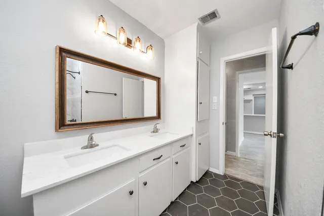 a bathroom with a double vanity sink mirror and