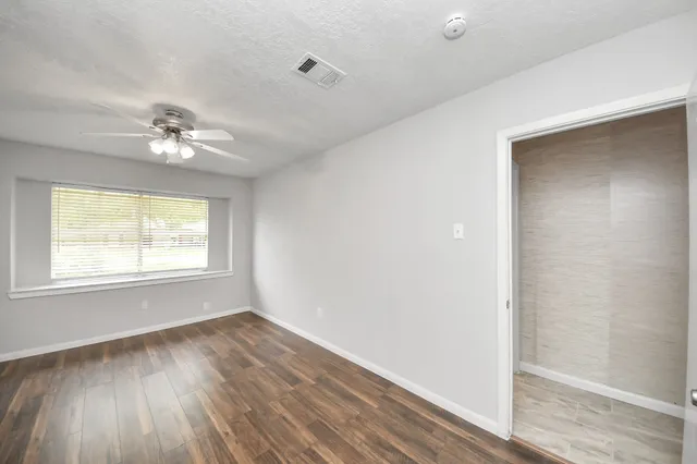 wooden floor in an empty room with a window
