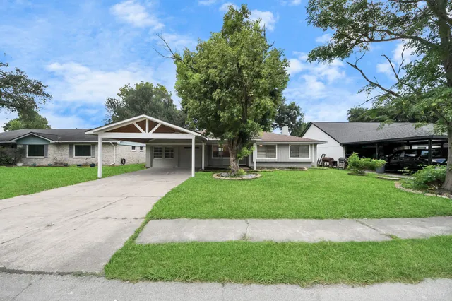 a front view of a house with a garden and yard