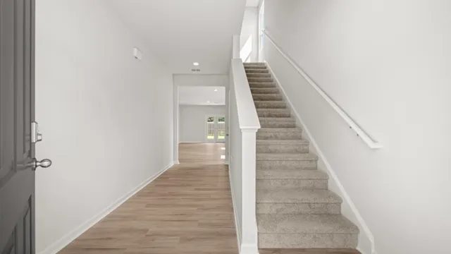 a view of a hallway with wooden floor and entryway