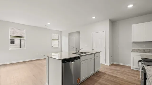 a kitchen with stainless steel appliances granite countertop a sink stove and cabinets