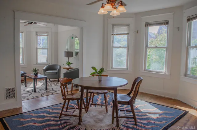 a view of a a dining room with furniture window and wooden floor