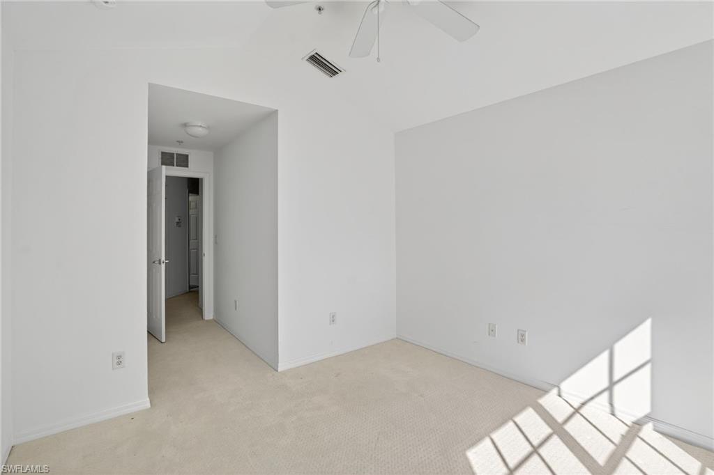 15995 Caldera Lane, Unit 69 Naples, FL 34110 - Photo 14 of 27 Empty room featuring lofted ceiling, light colored carpet, and ceiling fan