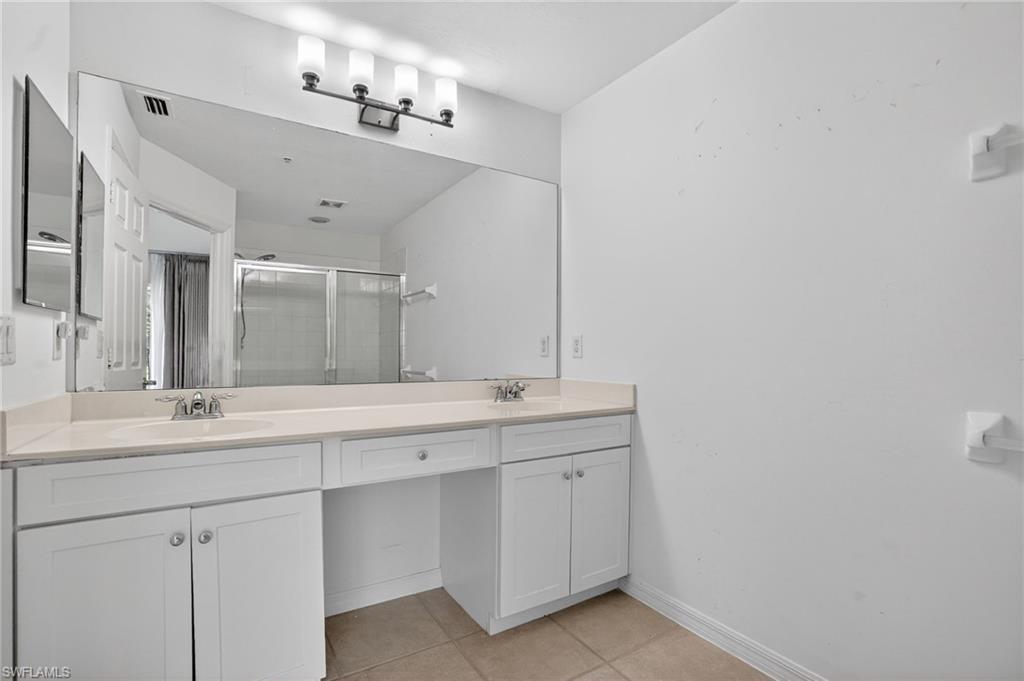 15995 Caldera Lane, Unit 69 Naples, FL 34110 - Photo 19 of 27 Full bathroom with double vanity, a shower stall, and light tile patterned floors