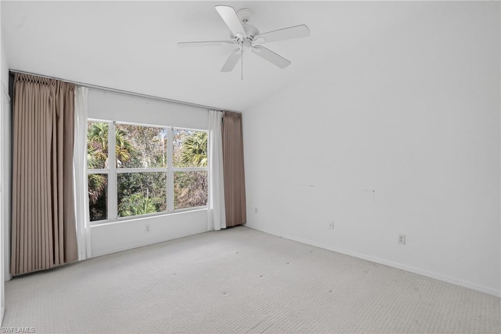 15995 Caldera Lane, Unit 69 Naples, FL 34110 - Photo 20 of 27 Carpeted empty room featuring vaulted ceiling and ceiling fan
