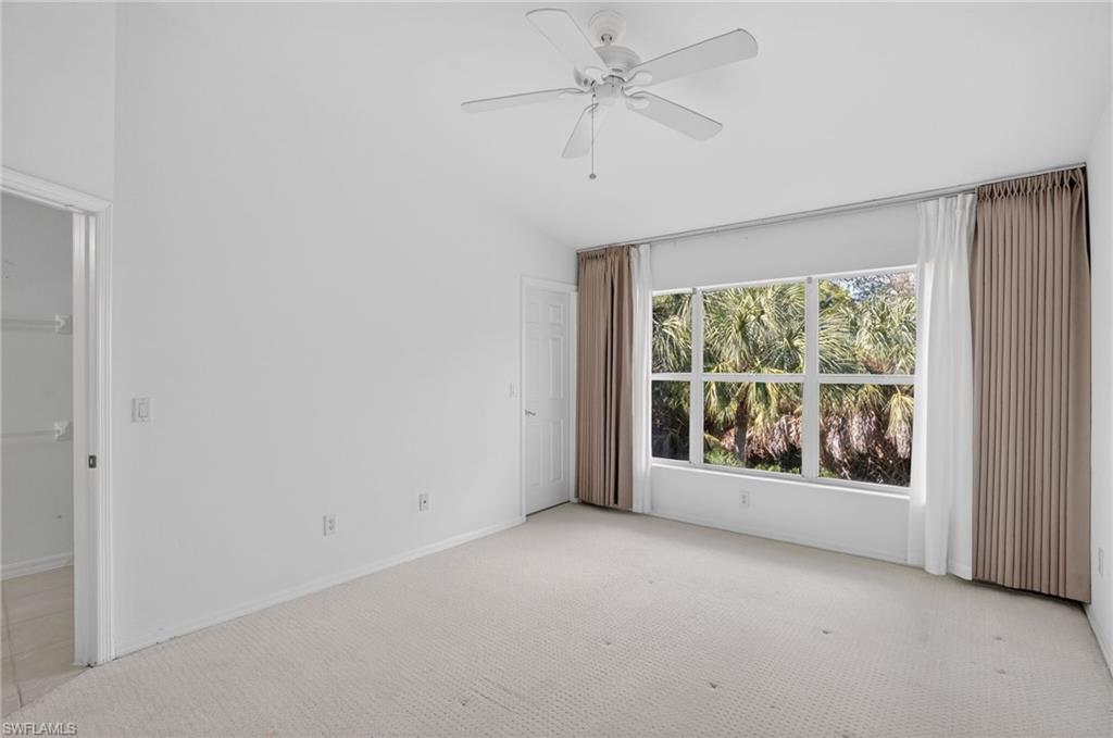 15995 Caldera Lane, Unit 69 Naples, FL 34110 - Photo 21 of 27 Empty room featuring light carpet, a ceiling fan, and lofted ceiling
