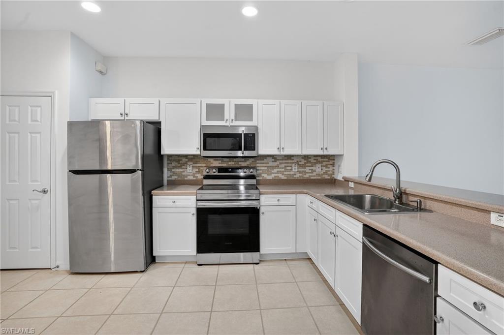 15995 Caldera Lane, Unit 69 Naples, FL 34110 - Photo 10 of 27 Kitchen featuring stainless steel appliances, white cabinets, decorative backsplash, and recessed lighting