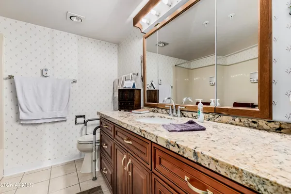 a bathroom with a granite countertop sink and a mirror