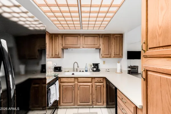 a kitchen with a sink cabinets stainless steel appliances and a window