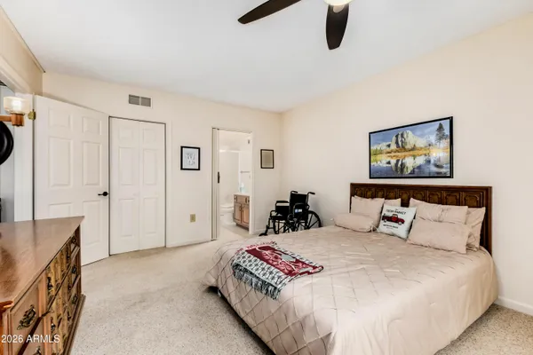 a bedroom with a bed and painting on the wall