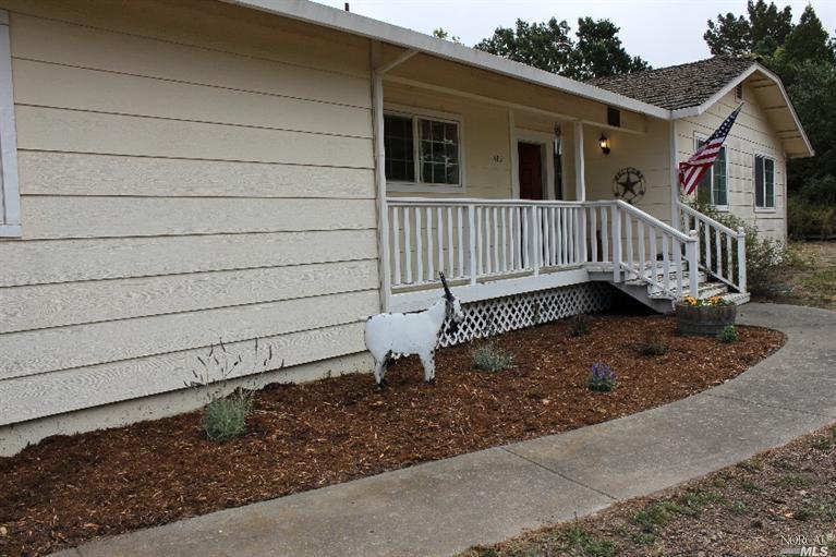 a view of a house with a small yard and wooden floor and fence