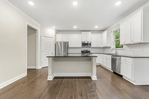 a kitchen with stainless steel appliances granite countertop a stove a sink and a refrigerator
