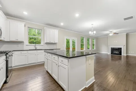 a kitchen with granite countertop a stove and cabinets