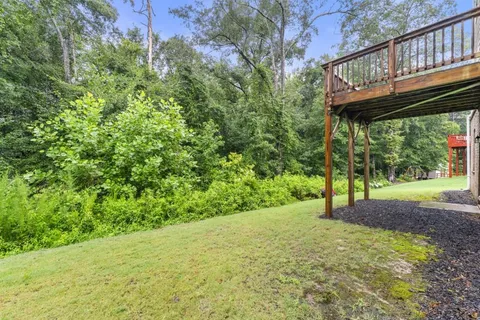 a view of a yard with plants and wooden fence
