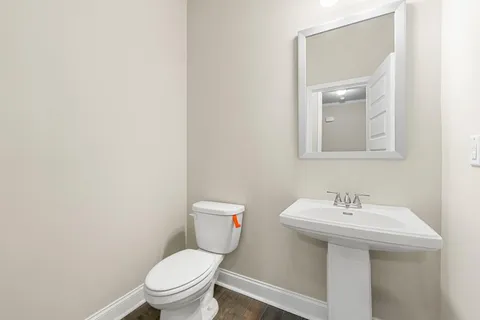 a bathroom with a toilet a sink and mirror