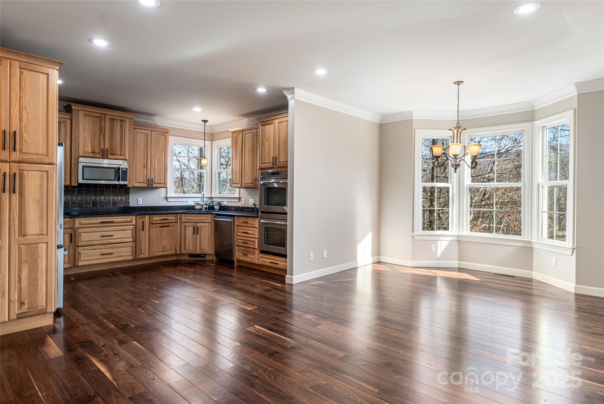 98 Sovereign Lane Fairview, NC 28730 - Photo 11 of 42 a kitchen with stainless steel appliances a microwave a stove a sink dishwasher a refrigerator and cabinets with wooden floor