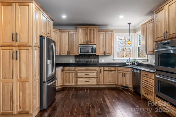 a kitchen with stainless steel appliances a refrigerator sink and microwave