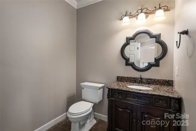 a bathroom with a granite countertop toilet sink and mirror