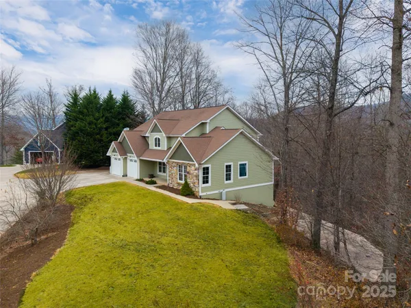 a view of a house with a large tree and a yard
