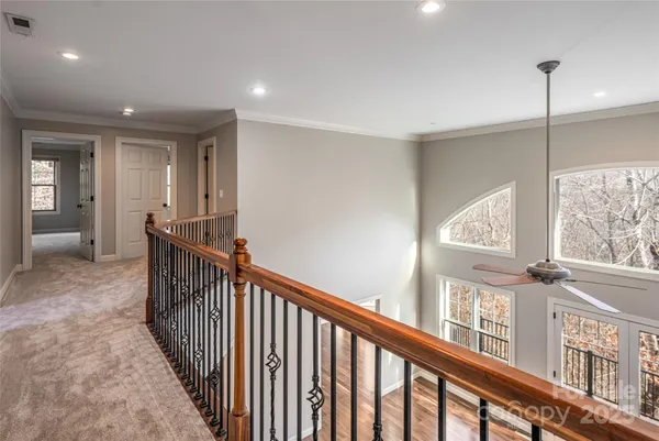 an empty room with windows and fan