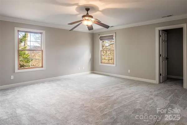 an empty room with windows and fan