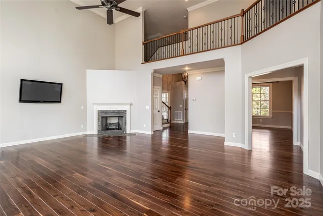 a view of a livingroom with wooden floor and a ceiling fan