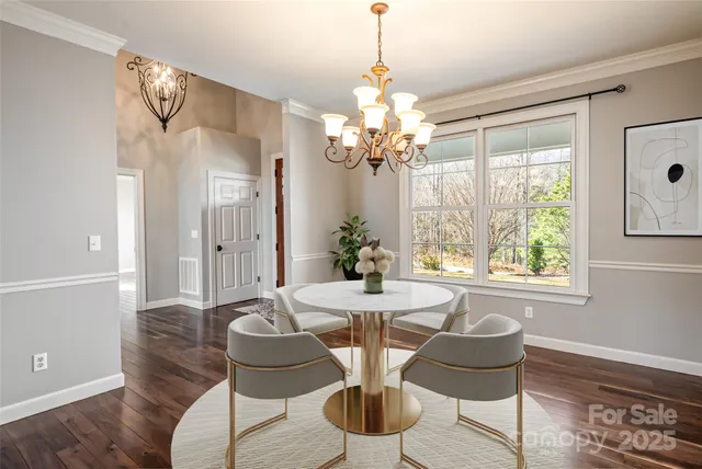 a dining room with furniture a chandelier and wooden floor