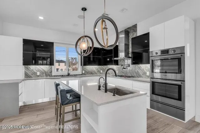 a kitchen with stainless steel appliances granite countertop a sink a stove and a microwave oven with cabinets