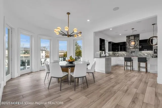 a view of a dining room with furniture a chandelier and wooden floor