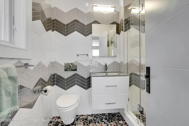 a bathroom with a sink a toilet and a mirror