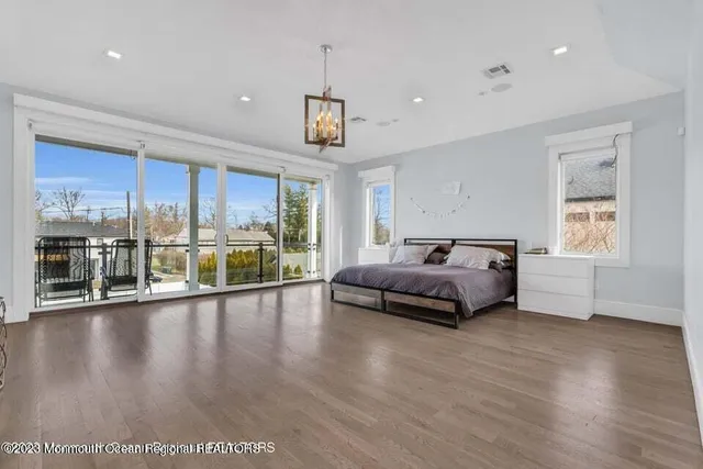 a spacious bedroom with a balcony a bed and a wooden floor