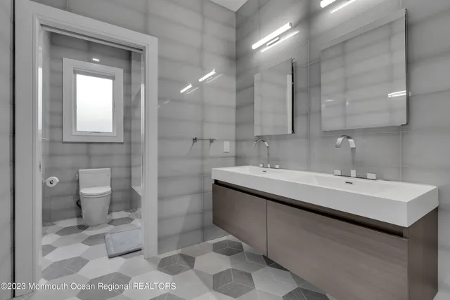 a bathroom with a double vanity sink mirror and toilet