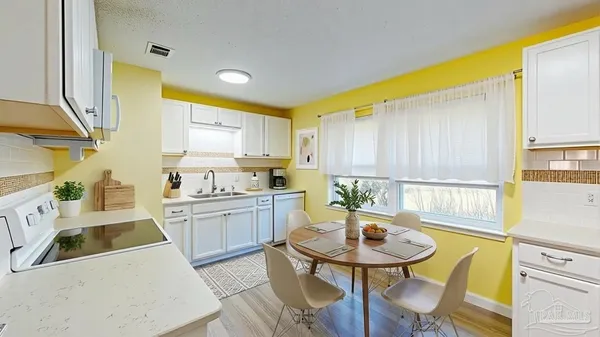 a kitchen with a sink a stove a kitchen island with a dining table and chairs