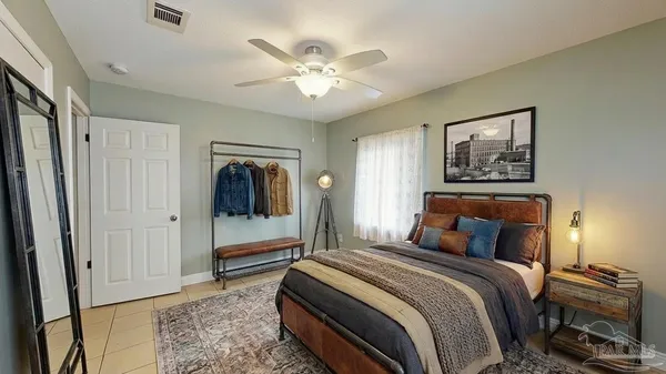 a bedroom with a large bed and a chandelier