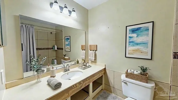 a bathroom with a sink vanity mirror and toilet