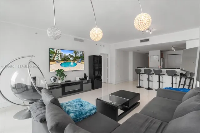 a living room with furniture a chandelier and a rug