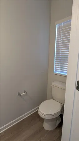 a white toilet sitting next to a small window