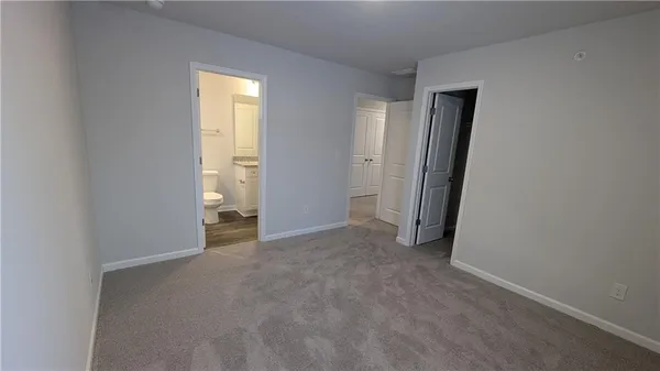 an empty room with closet and a bathroom