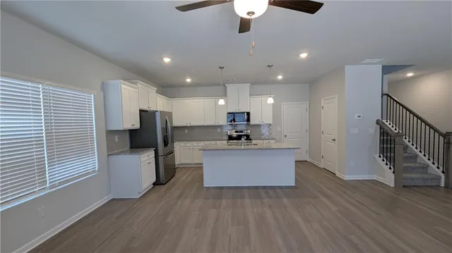 a kitchen with a refrigerator and a wooden floor